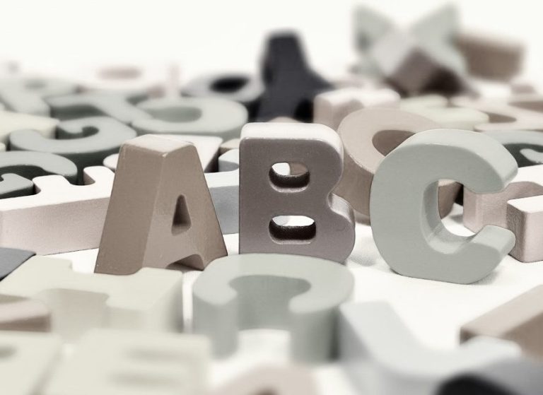 A, B und C stehend, viele weitere Buchstaben liegen verteilt drumherum.