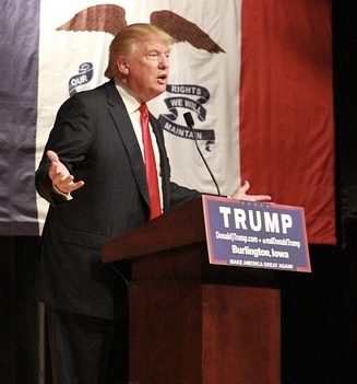 Trump im dunkelblauen Anzug mit ausgebreiteten Armen am Rednerpult