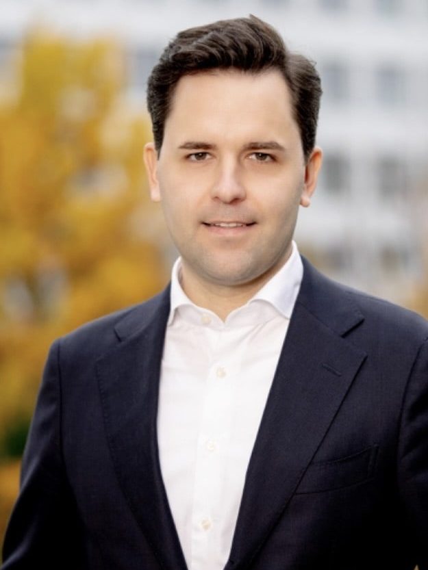 Ca. 35 Jahre alter dunkelhaariger Mann in schwarzem Sakko mit weißem Hemd