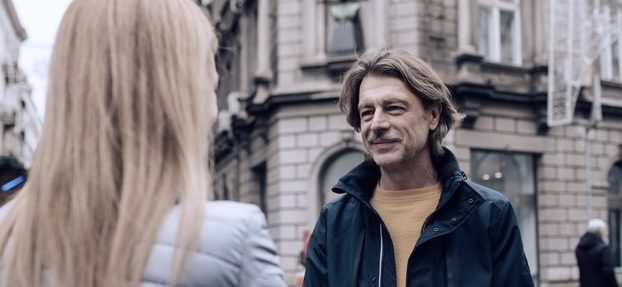 Wahlkämpfer im Gespräch Mann mittleren Alters spricht auf der Straße mit Frau, lange blonde Haare, nur ihre Rückseite ist zu sehen.