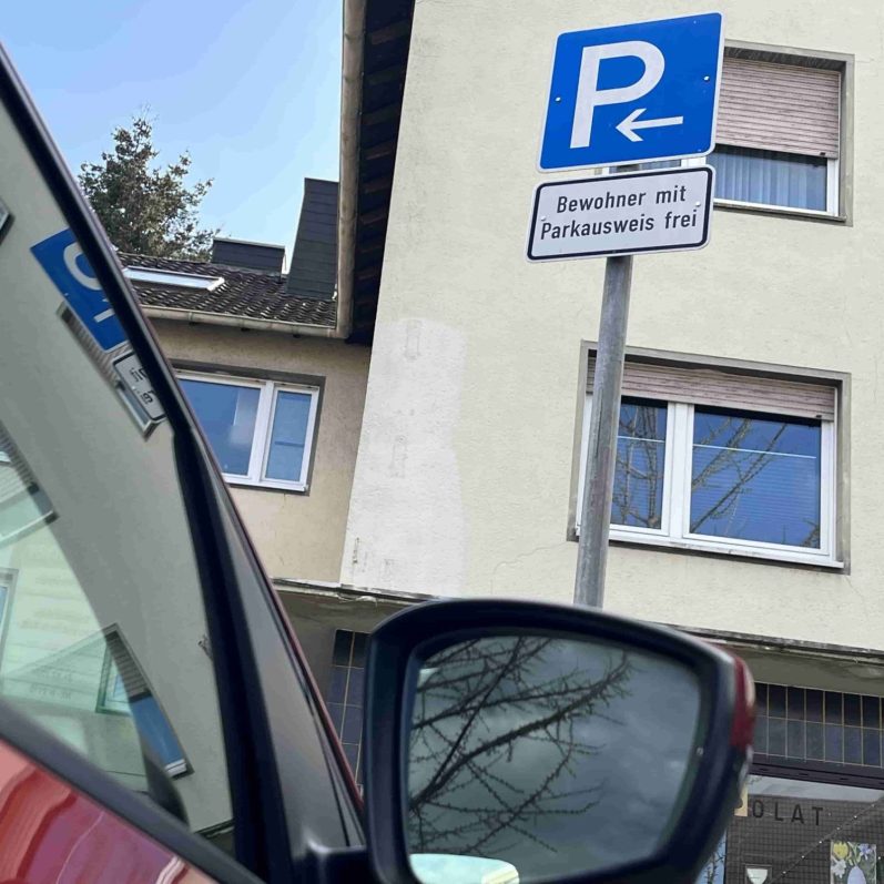 Auto im Anschnitt, dahinter Schild für Bewohnerparken